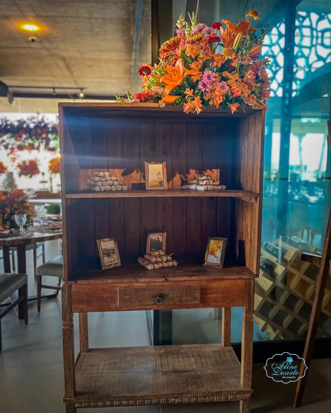 Estante de madeira rústica com arranjo de flores laranja